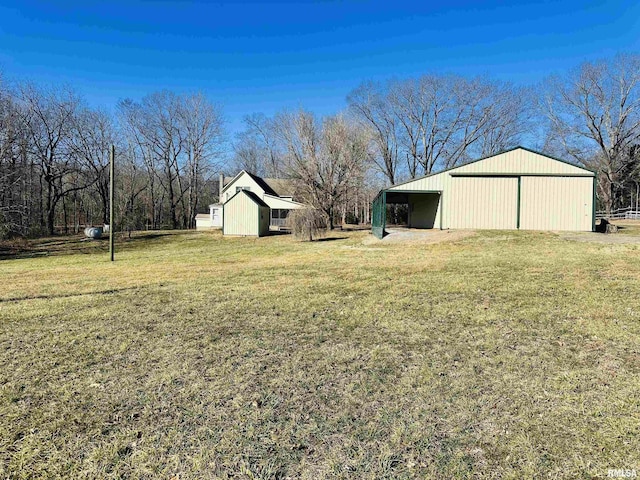 view of yard featuring a garage and an outbuilding