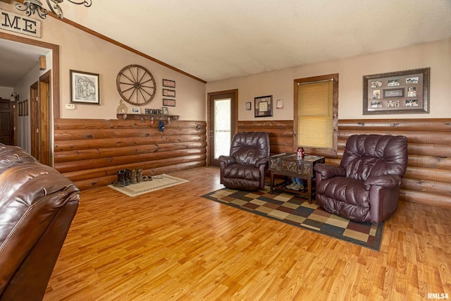 living room featuring rustic walls, light wood-type flooring, and vaulted ceiling