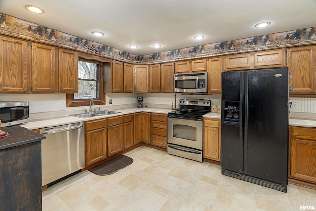 kitchen with stainless steel appliances, recessed lighting, brown cabinetry, and a sink