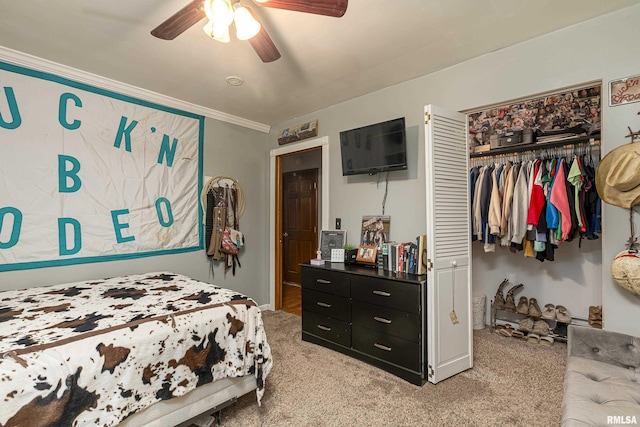 bedroom featuring ornamental molding, a closet, light carpet, and a ceiling fan