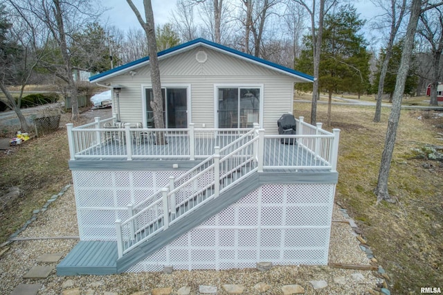 rear view of property featuring stairway and a wooden deck