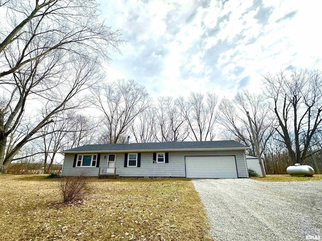 ranch-style house featuring a garage and gravel driveway