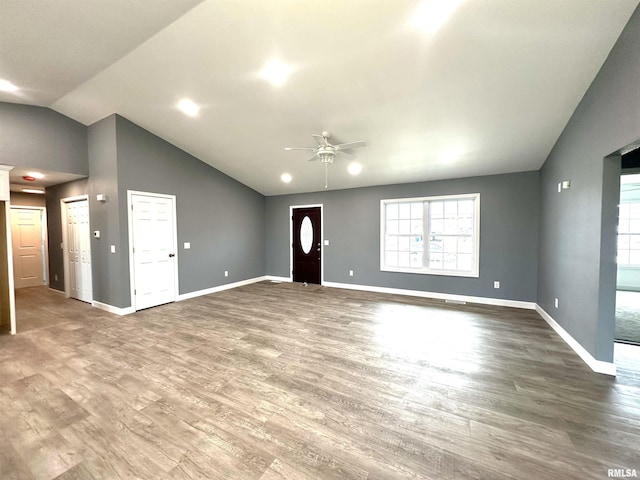 unfurnished living room with lofted ceiling, ceiling fan, baseboards, and wood finished floors