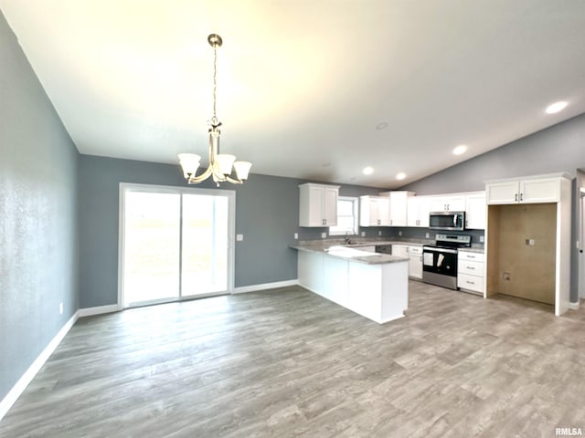 kitchen with decorative light fixtures, dark countertops, appliances with stainless steel finishes, white cabinets, and a peninsula