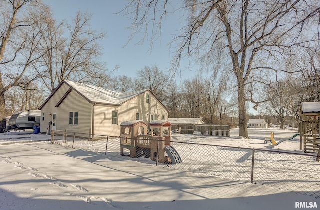 view of front of house featuring a playground and fence