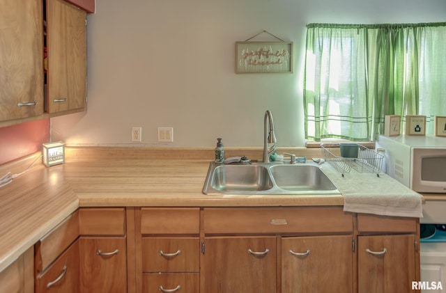 600 N Washington St, Sparta, IL 62286 - kitchen with light countertops, a sink, white microwave, and brown cabinetry