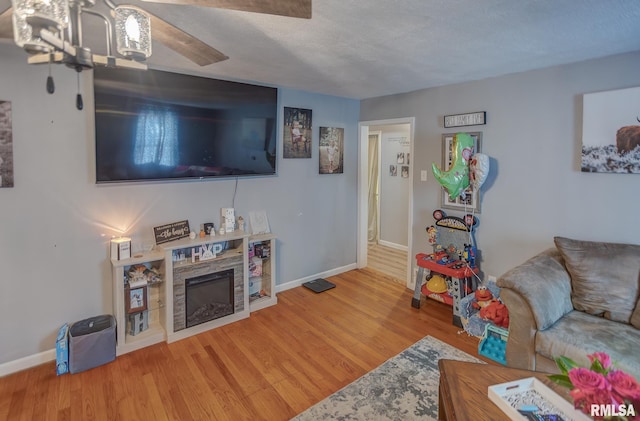 living room with a fireplace, baseboards, and wood finished floors