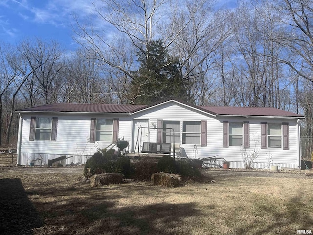 manufactured / mobile home with a front yard and metal roof