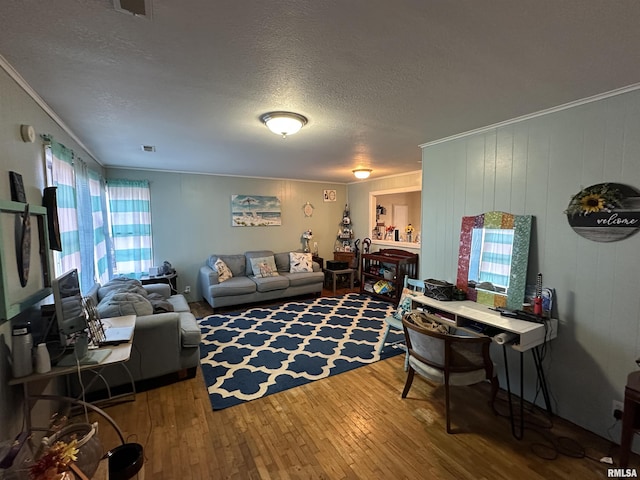 living area featuring ornamental molding, visible vents, a textured ceiling, and hardwood / wood-style flooring