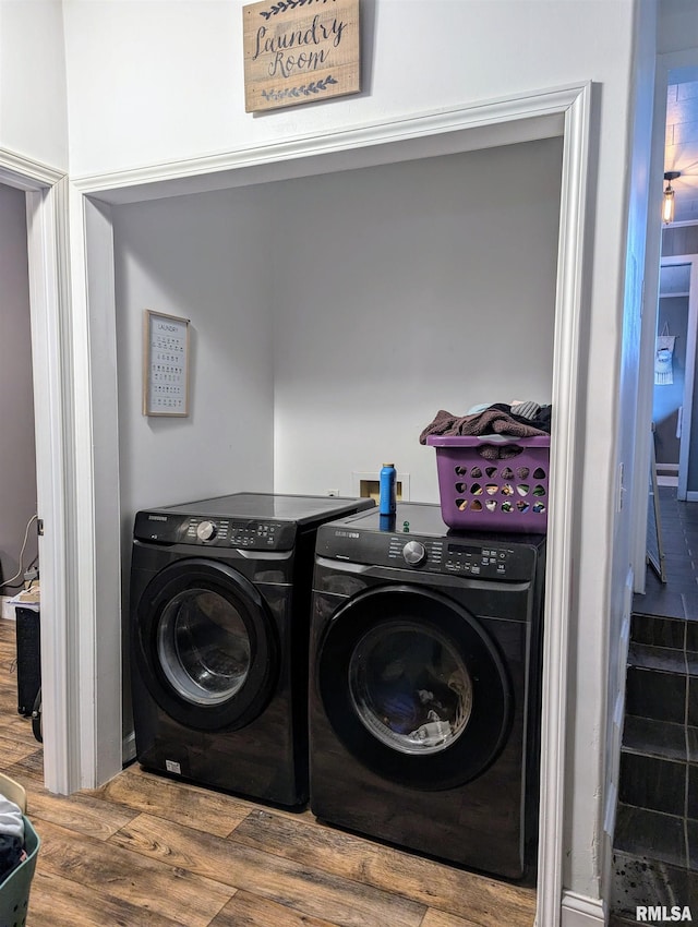 laundry area with washing machine and dryer, laundry area, and wood finished floors