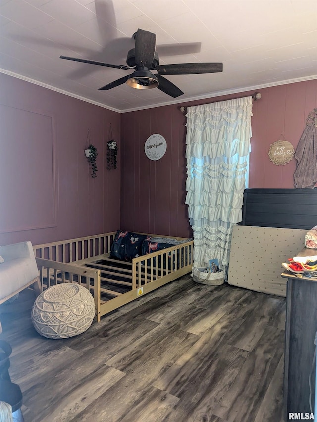 bedroom featuring ornamental molding, a ceiling fan, and dark wood-style floors