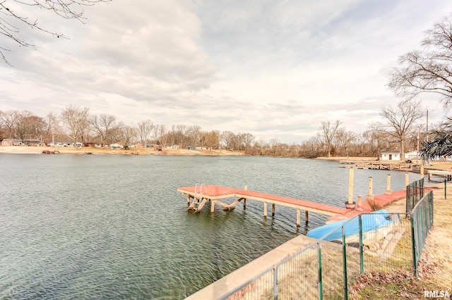 dock area with fence and a water view