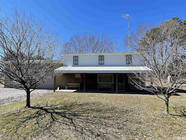 view of front of home with a garage, metal roof, and a porch