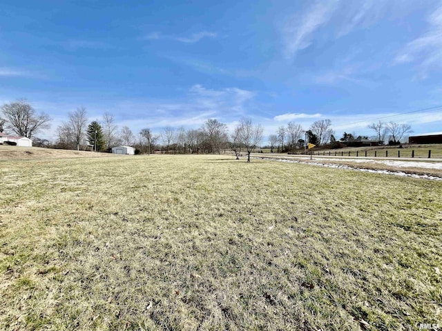 view of yard with an outbuilding, a storage unit, and a rural view