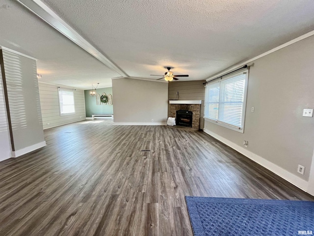 unfurnished living room with a textured ceiling, a baseboard radiator, ceiling fan with notable chandelier, dark wood-style flooring, and a fireplace