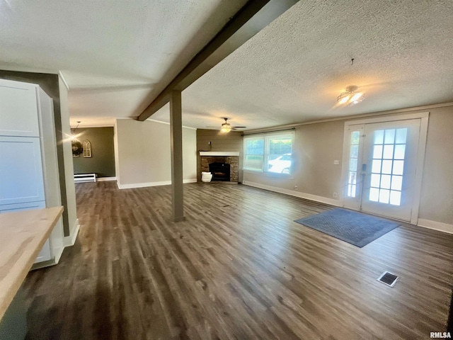 8065 E State Route 146th Hwy, Grantsburg, IL 62943 - unfurnished living room featuring dark wood-style floors, a fireplace, a textured ceiling, baseboards, and baseboard heating