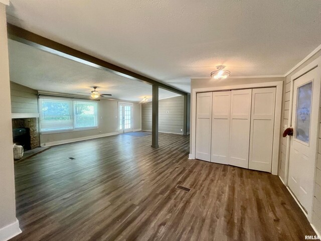 8065 E State Route 146th Hwy, Grantsburg, IL 62943 - unfurnished living room with a fireplace, dark wood finished floors, a textured ceiling, a ceiling fan, and baseboards