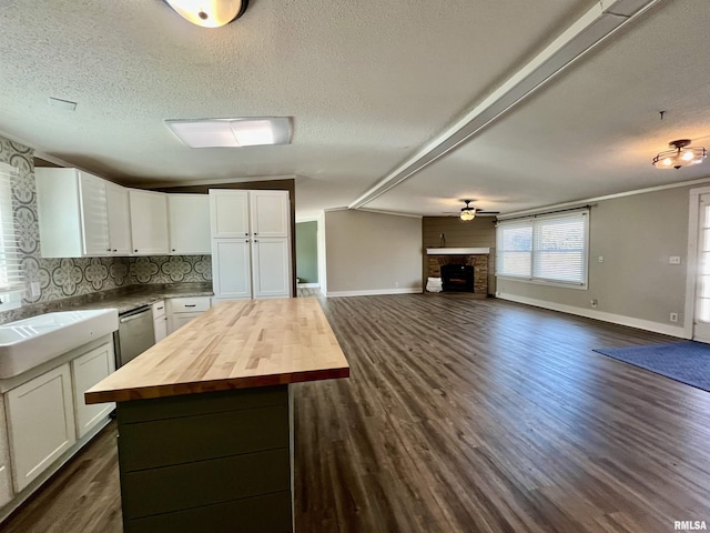 kitchen featuring open floor plan, butcher block counters, white cabinets, and dishwasher