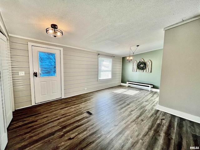 entryway featuring baseboards, wood finished floors, baseboard heating, crown molding, and a textured ceiling