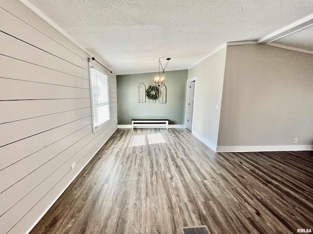 unfurnished dining area with a textured ceiling, a chandelier, and wood finished floors