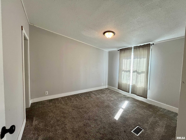 spare room featuring a textured ceiling, carpet flooring, visible vents, and baseboards