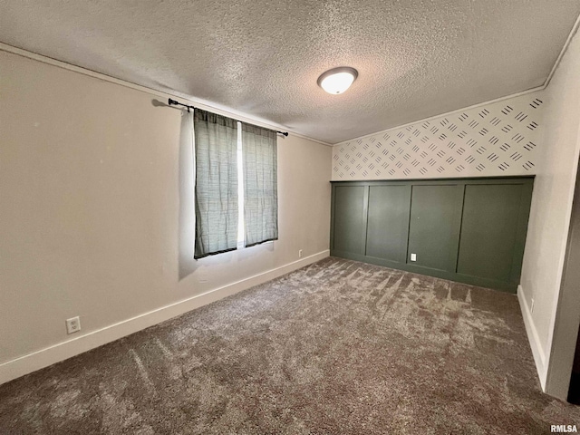 interior space featuring carpet, baseboards, a textured ceiling, and ornamental molding