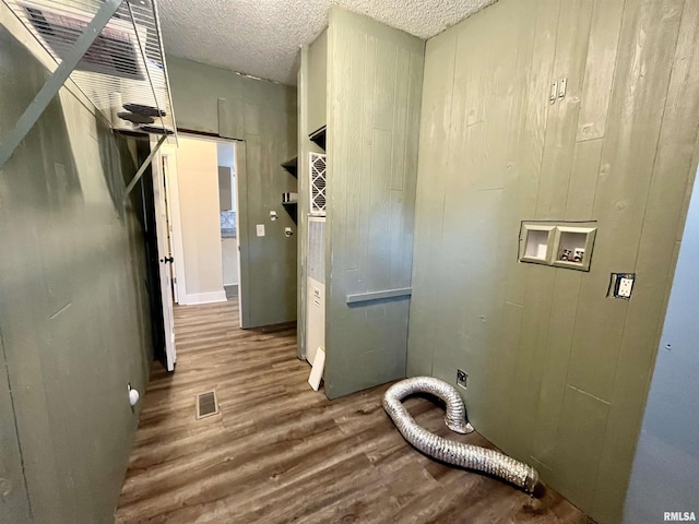 washroom with visible vents, wood finished floors, a textured ceiling, washer hookup, and electric dryer hookup