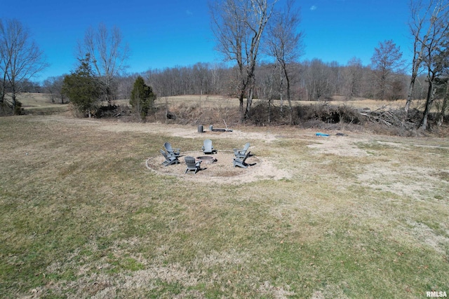 view of yard featuring an outdoor fire pit and a rural view