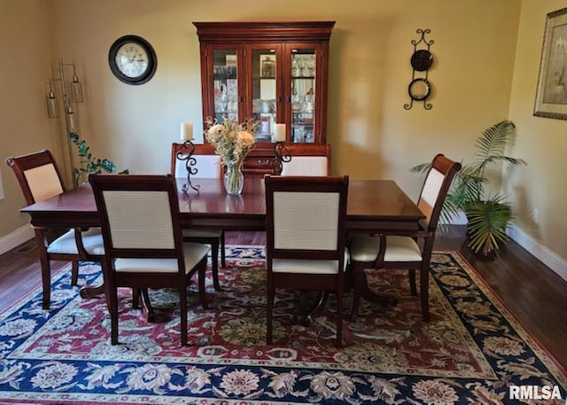 dining space with baseboards and wood finished floors