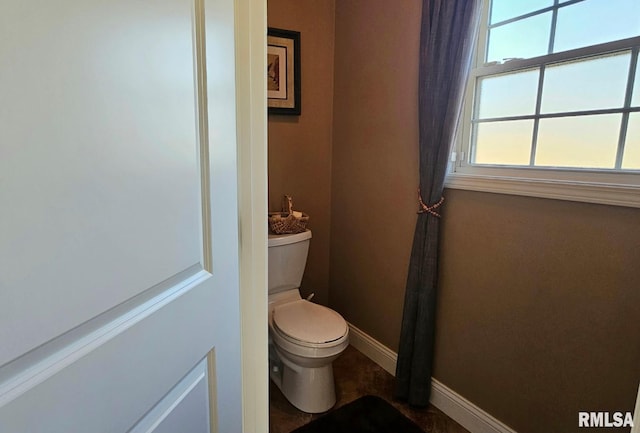 bathroom featuring toilet and baseboards