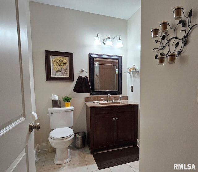 bathroom featuring toilet, vanity, tile patterned flooring, baseboards, and walk in shower