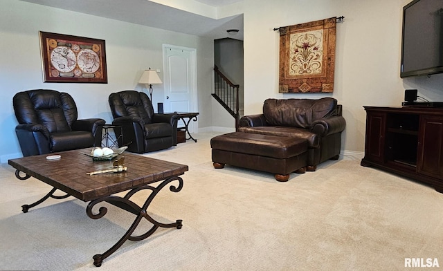 living area featuring stairs, baseboards, and light colored carpet