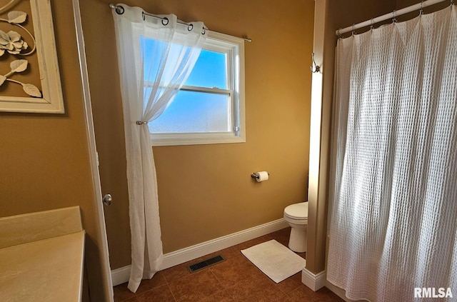 full bath featuring toilet, tile patterned floors, visible vents, and baseboards