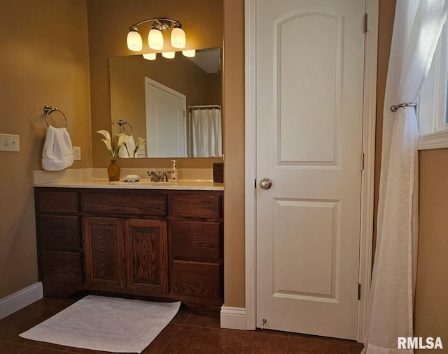 bathroom with baseboards, vanity, and tile patterned floors