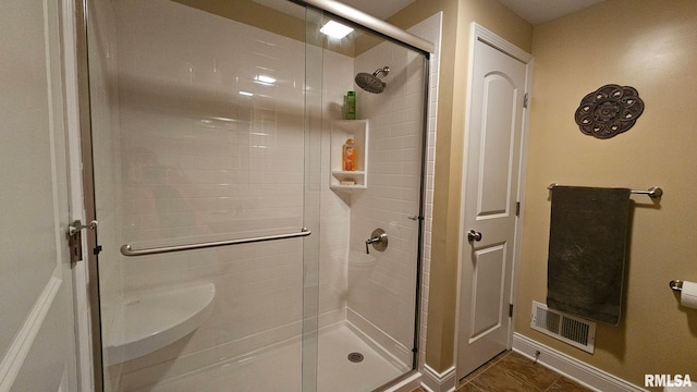 full bathroom featuring a stall shower and visible vents