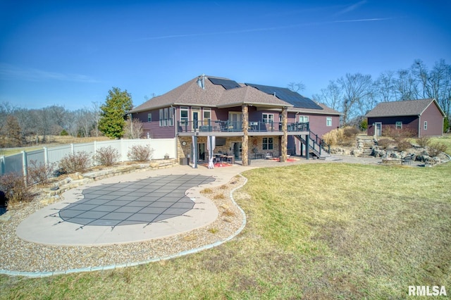 back of house featuring solar panels, a lawn, a patio area, a deck, and stairs