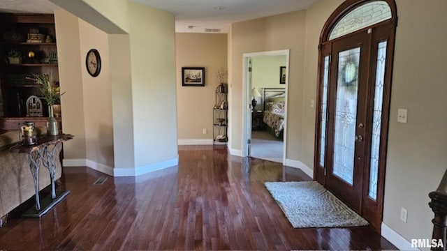 foyer with visible vents, baseboards, and wood finished floors