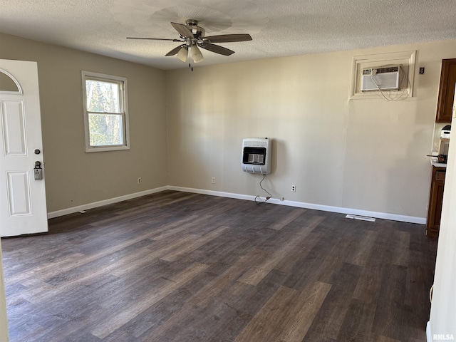 empty room with baseboards, ceiling fan, dark wood-type flooring, heating unit, and a wall mounted AC