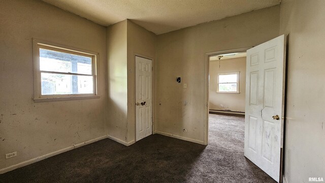 202 S Liberty St, Marion, IL 62959 - spare room with baseboards, a textured ceiling, dark carpet, and a baseboard radiator