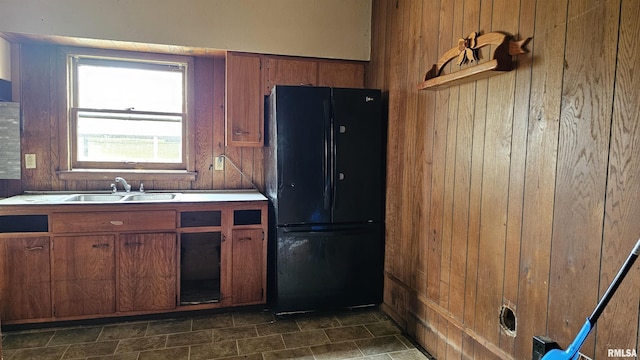 202 S Liberty St, Marion, IL 62959 - kitchen featuring freestanding refrigerator, brown cabinetry, light countertops, a sink, and wooden walls