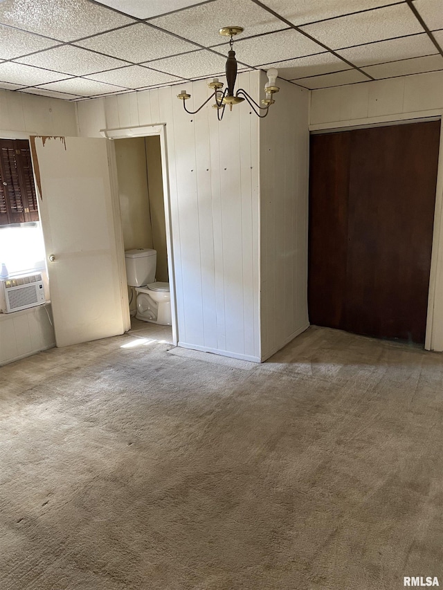 unfurnished bedroom featuring a chandelier, carpet flooring, and a paneled ceiling