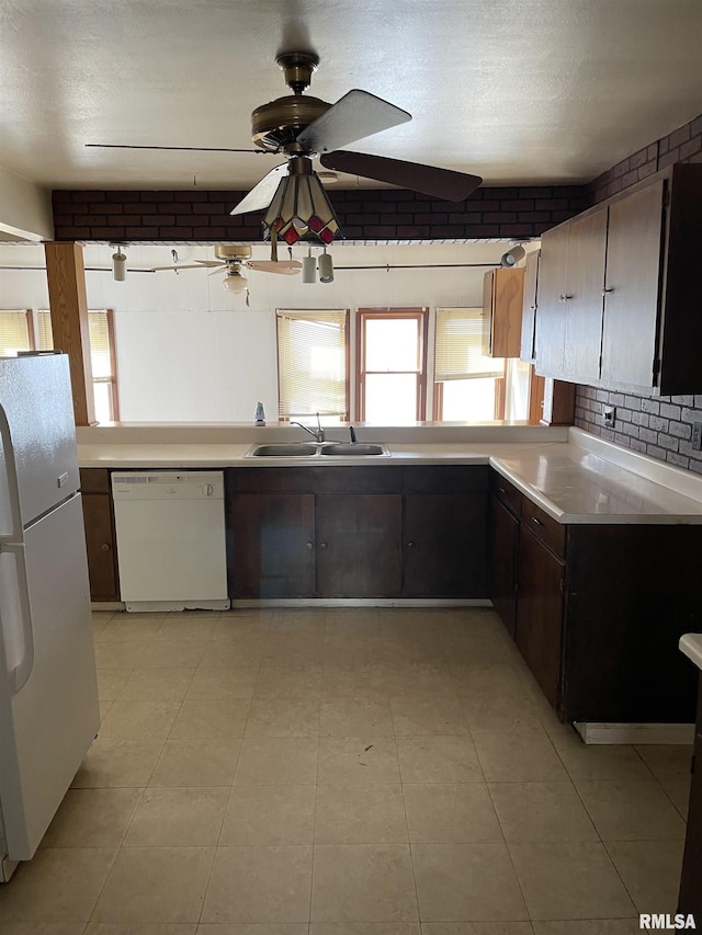 kitchen with white appliances, decorative backsplash, a ceiling fan, light countertops, and a sink