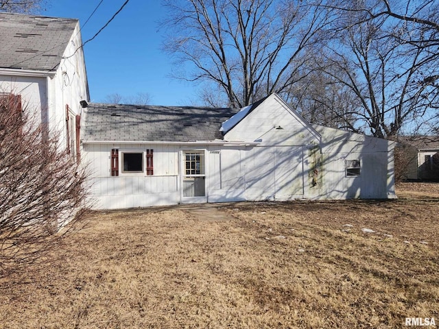 rear view of property with roof with shingles