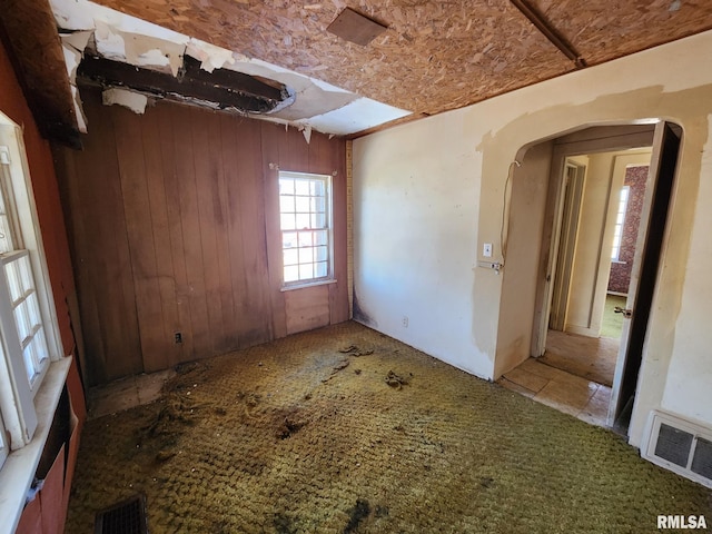 empty room featuring visible vents and arched walkways