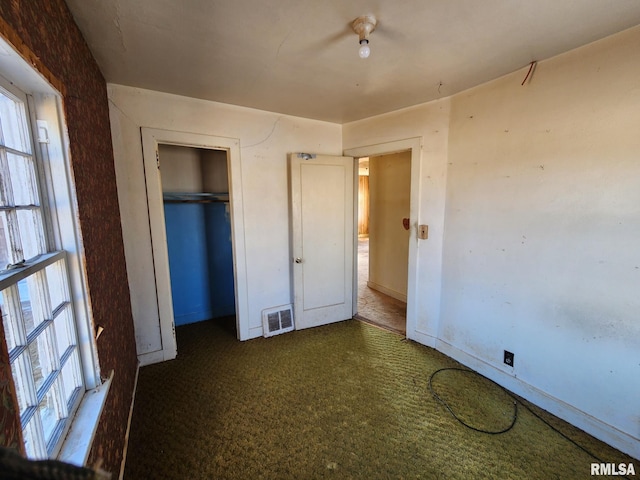 unfurnished bedroom with multiple windows, a closet, carpet, and visible vents