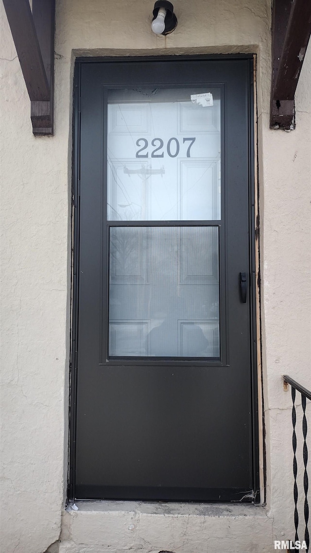 property entrance with stucco siding