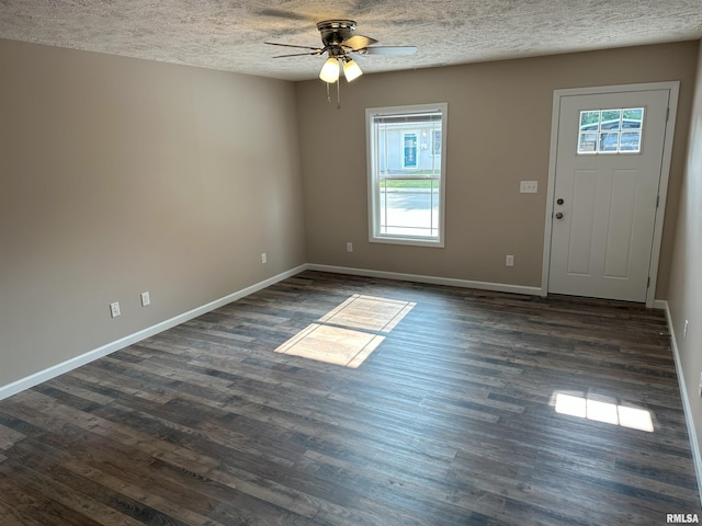 foyer with dark wood-type flooring, ceiling fan, a textured ceiling, and baseboards