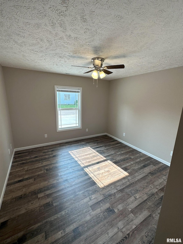 empty room featuring dark wood-type flooring, a textured ceiling, baseboards, and a ceiling fan