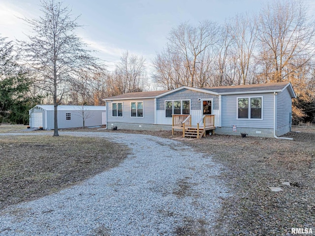 manufactured / mobile home featuring crawl space, driveway, and an outdoor structure