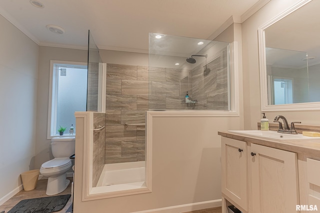 full bathroom featuring baseboards, toilet, crown molding, vanity, and a walk in shower